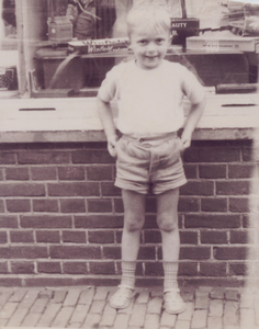 862747 Portret van de 5-jarige Alex Jupijn, voor de kruidenierswinkel van de gezusters van der Valk (Oranjestraat 77) ...
